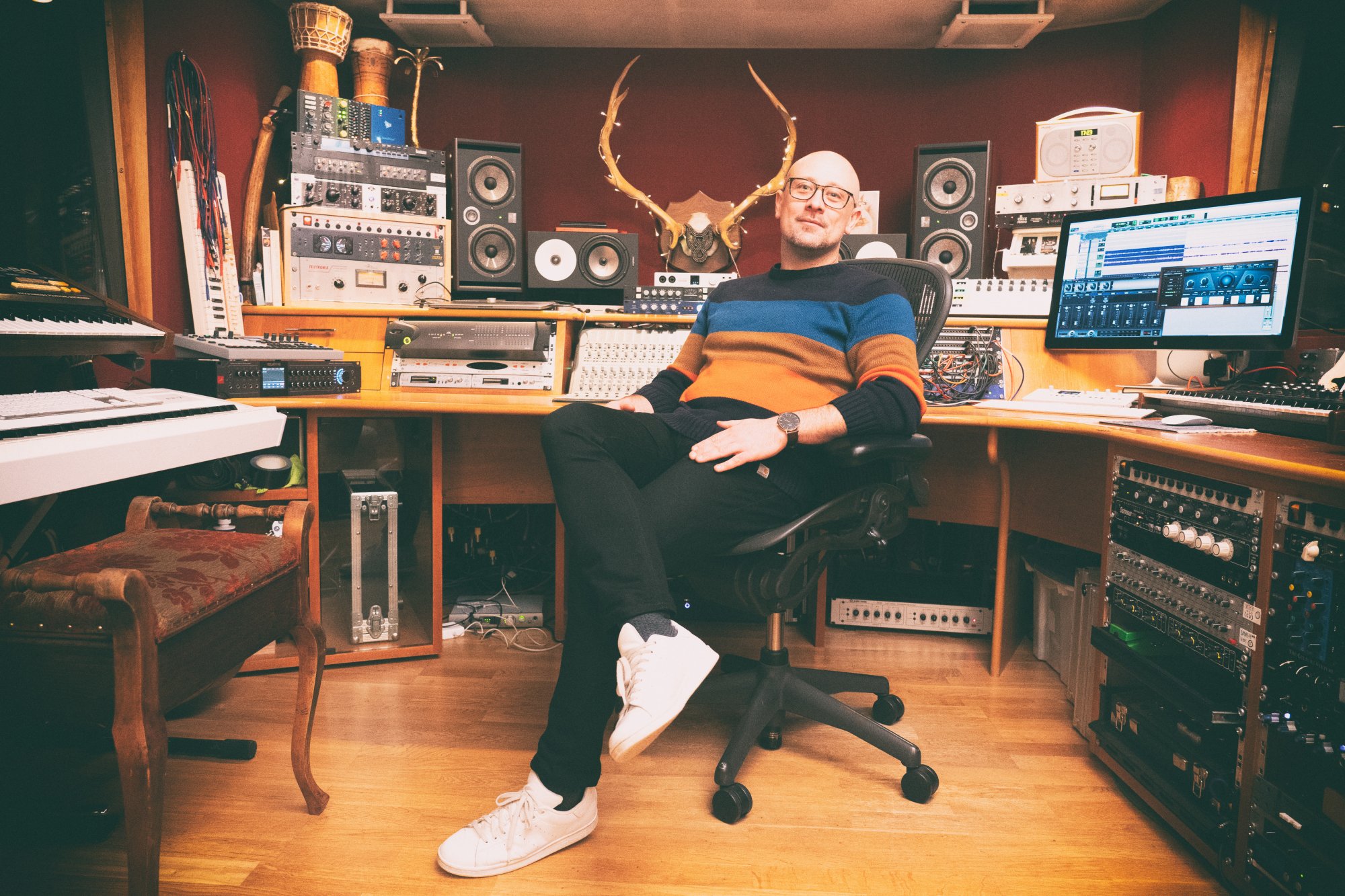 Producer Tom Fuller sitting on a chair in his studio The Cabin
